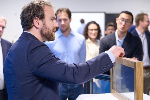 At an event marking the opening of AeroShield's new pilot manufacturing facility in Waltham, Massachusetts, Aaron Baskerville-Bridges, co-founder and vice president of operations, shows an AeroShield prototype window with the ability to cut energy losses in half.