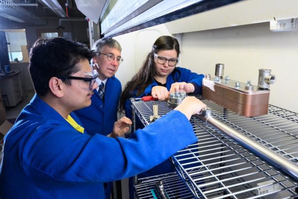 Based on a series of analytical studies, MIT chemical engineers have come up with an idea that would enable long-haul trucks to use clean-burning hydrogen in place of diesel fuel, thereby reducing their carbon emissions. Left to right: Sayandeep Biswas, William Green, and Kariana Moreno Sader are now building an experiment to test and fine-tune equipment key to their promising approach. 