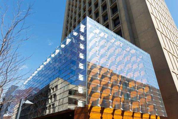 The airy exterior of the Moghadam Building, designed by AW-ARCH to complement and extend the Green Building’s Brutalist tower, is sheathed with an innovative system of wood composite overlaid with bracketed glass panels that reflect the surrounding trees and green space.