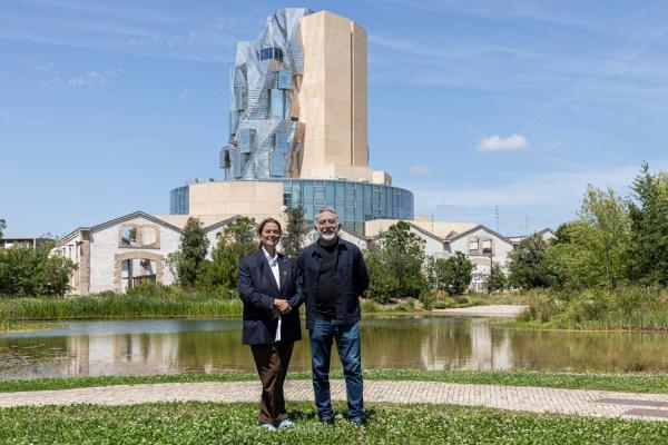 Maja Hoffmann (left), founder and president of the LUMA Foundation, and Hashim Sarkis, dean of the MIT School of Architecture and Planning, at LUMA Arles in the Parc des Ateliers in France. This 27-acre interdisciplinary campus is an experimental site of exhibitions, artists’ residencies, research laboratories, and educational programs that includes The Tower, a multipurpose space designed by Frank Gehry, seen here amid 19th-century factory buildings.